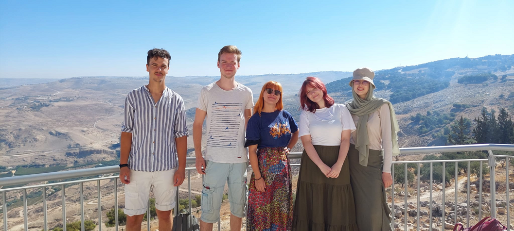 Auf dem Bild sind fünf Teilnehmer_Innen der Lehgrabung bei einem Ausflug auf Mount Nebo zu sehen. Im Hintergrund die malerische Landschaft.